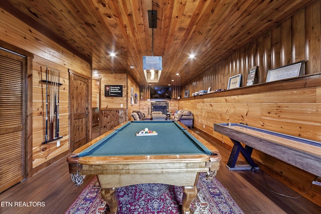 recreation room with a stone fireplace, wooden ceiling, pool table, dark hardwood / wood-style flooring, and wood walls