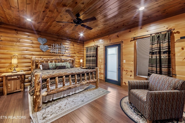 bedroom with dark wood-type flooring, ceiling fan, and log walls