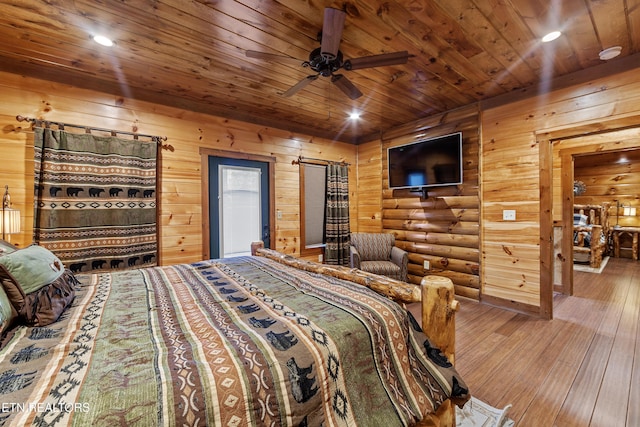 bedroom with wooden ceiling, hardwood / wood-style flooring, ceiling fan, and log walls