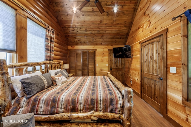 bedroom with wooden ceiling, vaulted ceiling, light wood-type flooring, and wooden walls