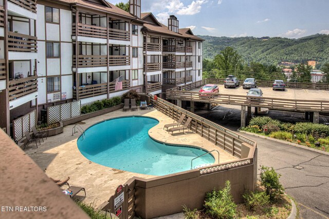 view of swimming pool with a mountain view and a patio