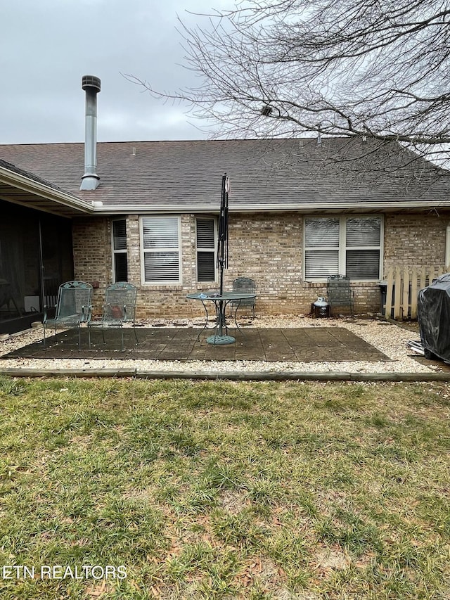 rear view of property featuring a lawn and a patio