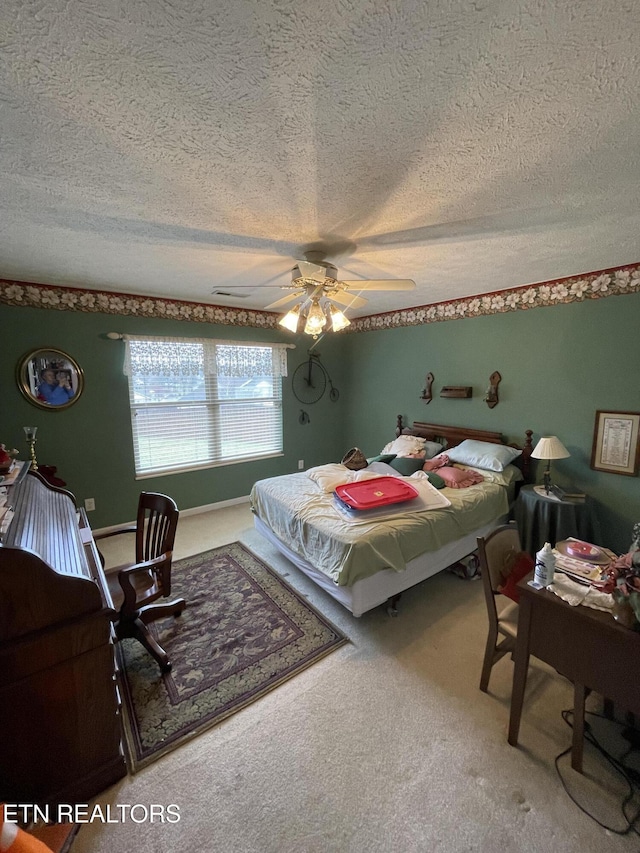 bedroom featuring ceiling fan, carpet, and a textured ceiling