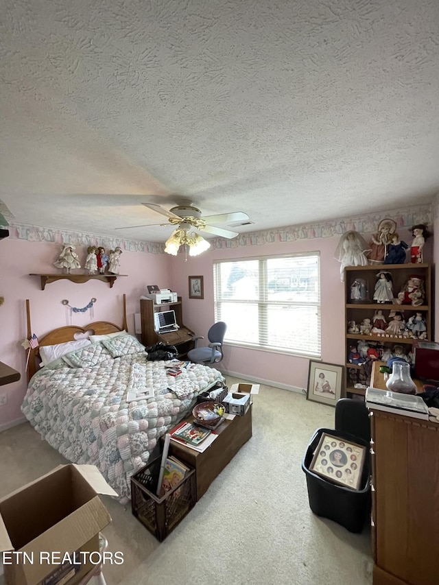 carpeted bedroom with ceiling fan and a textured ceiling