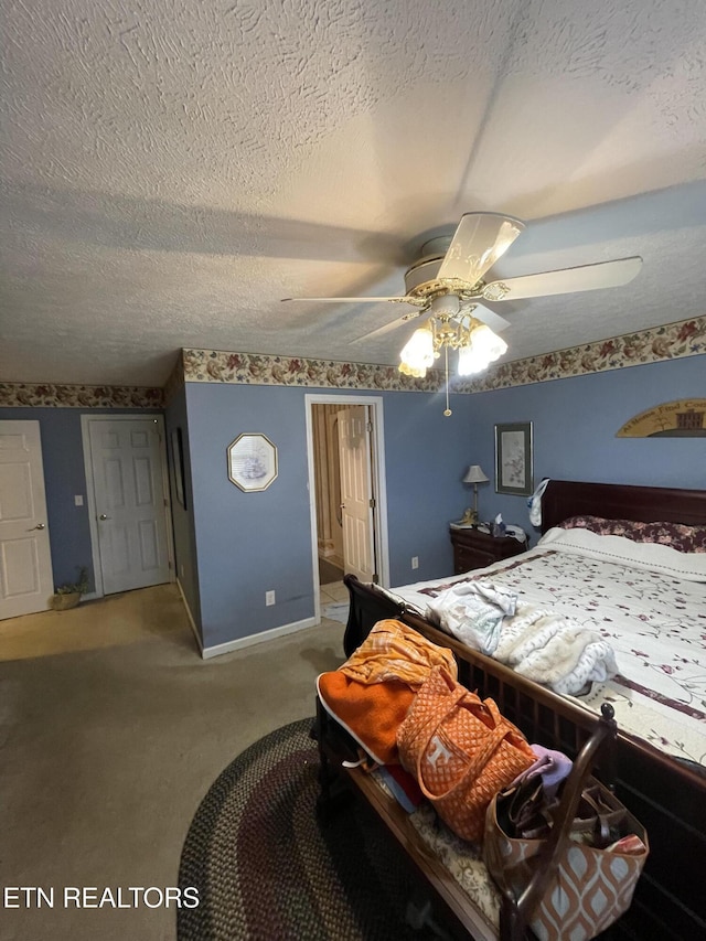 carpeted bedroom featuring ceiling fan and a textured ceiling