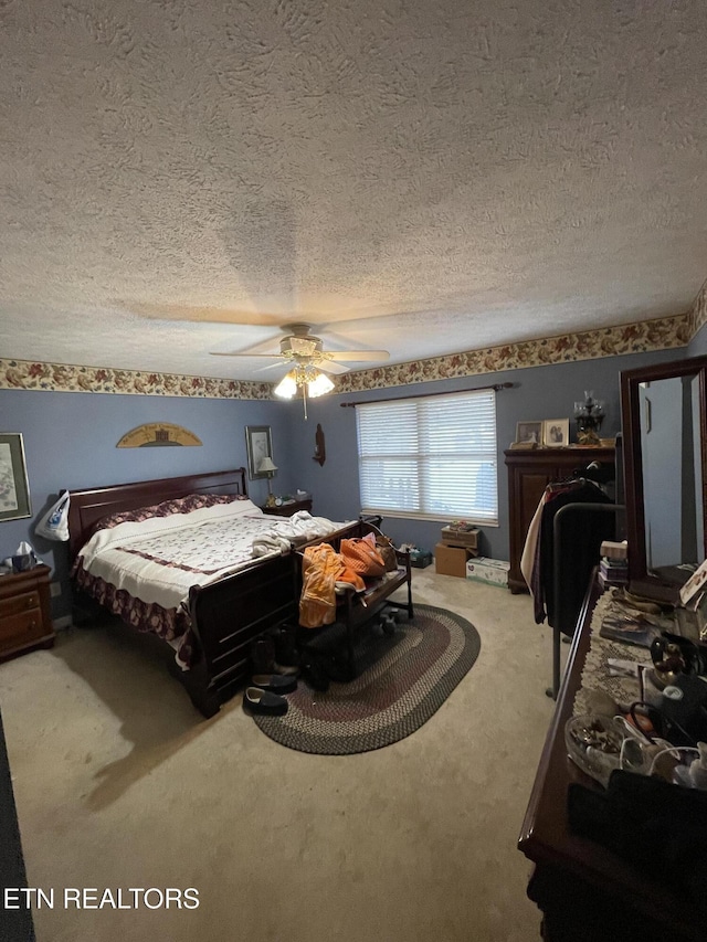 bedroom featuring carpet, a textured ceiling, and ceiling fan