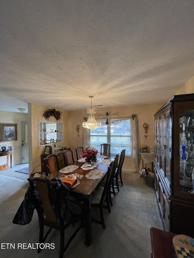 carpeted dining area with a notable chandelier and a textured ceiling