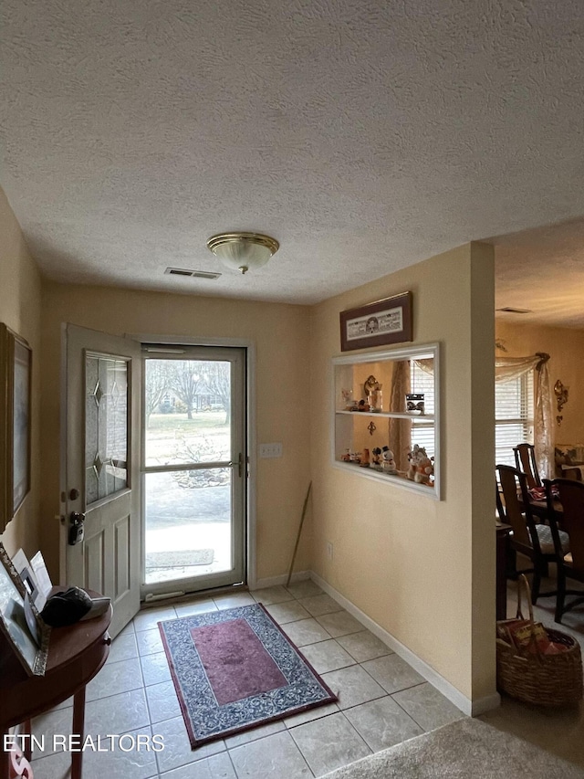 tiled foyer entrance with a textured ceiling