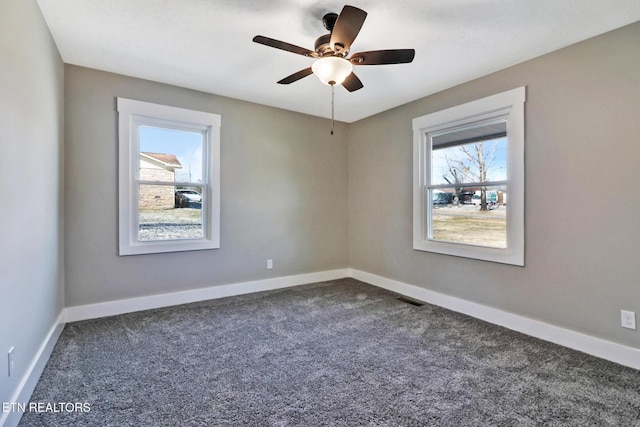 unfurnished room with ceiling fan and dark carpet