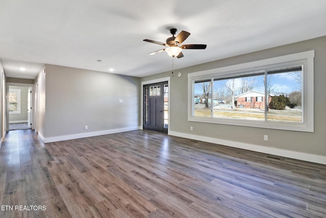 interior space with ceiling fan, a healthy amount of sunlight, and dark hardwood / wood-style floors