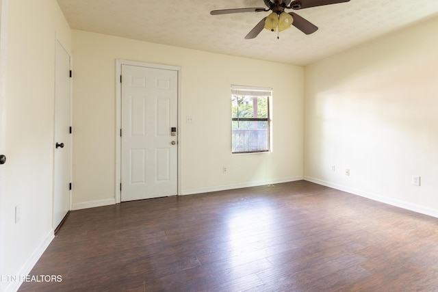 empty room featuring ceiling fan, a textured ceiling, and dark hardwood / wood-style flooring