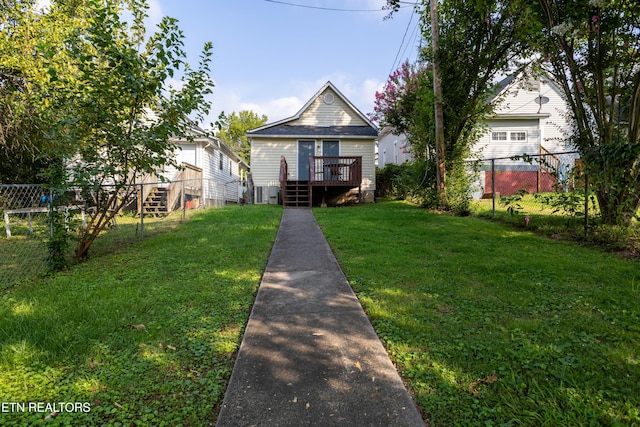 view of front facade featuring a wooden deck and a front yard