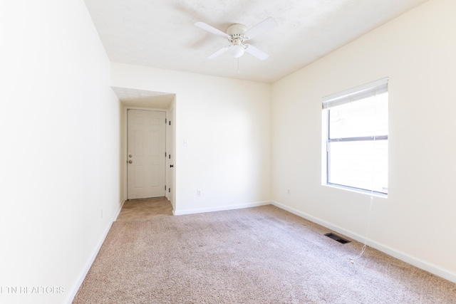 carpeted spare room featuring ceiling fan