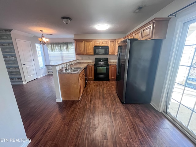 kitchen featuring sink, hanging light fixtures, dark hardwood / wood-style floors, kitchen peninsula, and black appliances