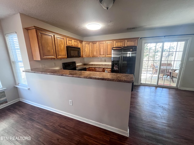 kitchen with plenty of natural light, kitchen peninsula, and black appliances