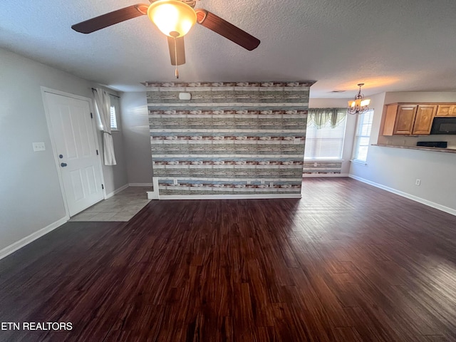 interior space with ceiling fan with notable chandelier, hardwood / wood-style floors, and a textured ceiling