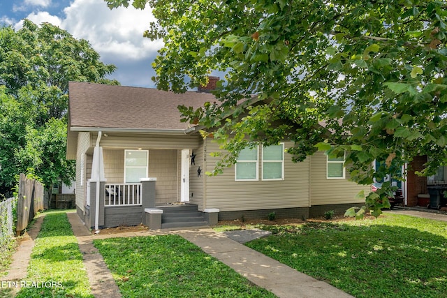 bungalow-style home featuring covered porch and a front lawn