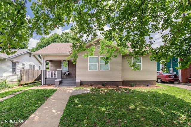 bungalow-style house featuring covered porch and a front yard