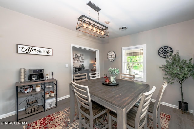 dining room with dark hardwood / wood-style flooring and a chandelier