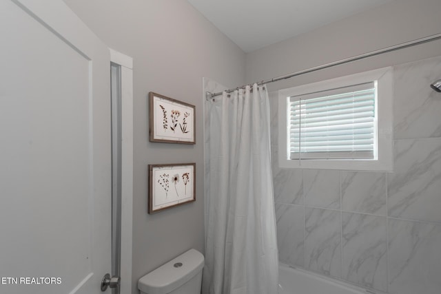 bathroom with shower / bath combo and toilet