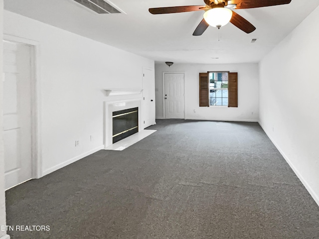 unfurnished living room featuring ceiling fan and dark colored carpet