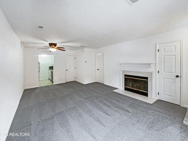 unfurnished living room with ceiling fan and dark carpet