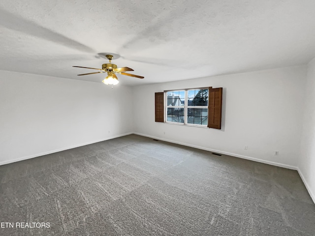 spare room with ceiling fan, dark carpet, and a textured ceiling