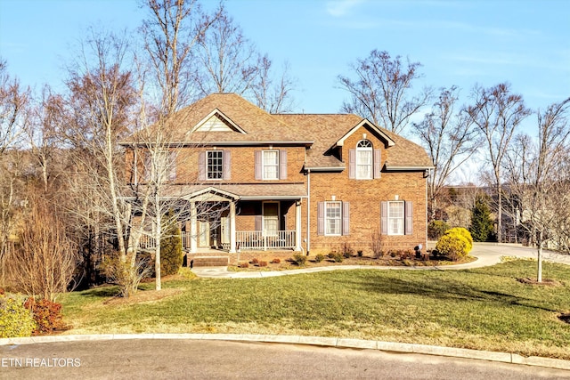 view of front of home featuring covered porch and a front lawn