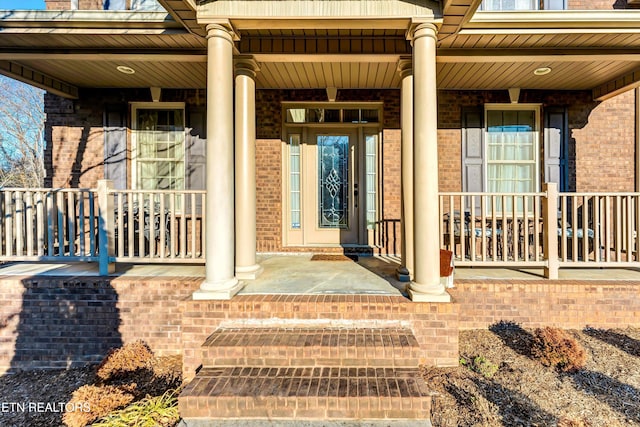 view of exterior entry featuring covered porch