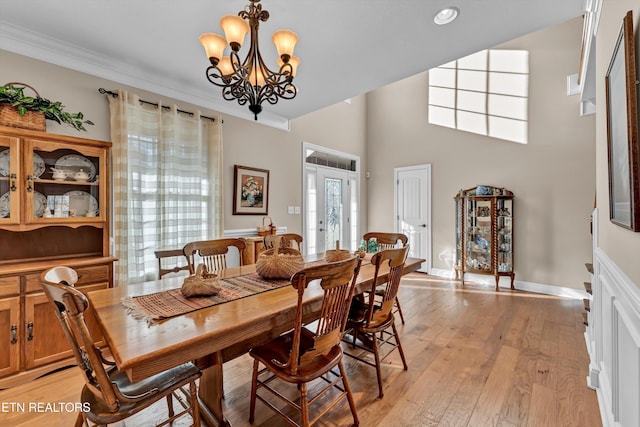 dining area featuring ornamental molding, light hardwood / wood-style flooring, and a notable chandelier