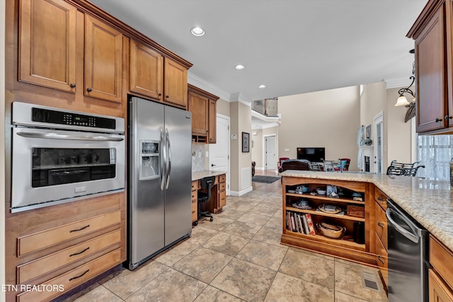 kitchen with crown molding, decorative light fixtures, appliances with stainless steel finishes, light stone countertops, and decorative backsplash