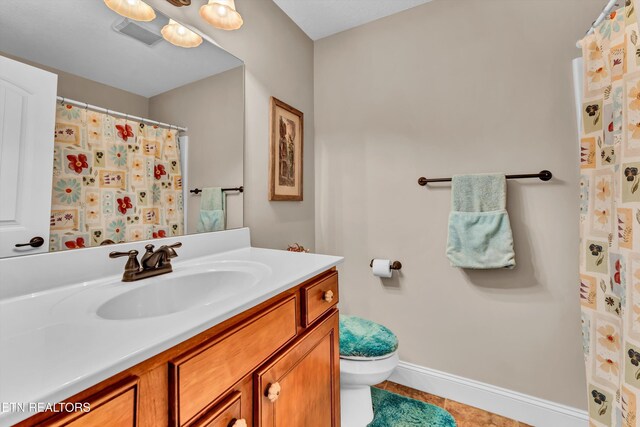 bathroom with vanity, tile patterned floors, and toilet