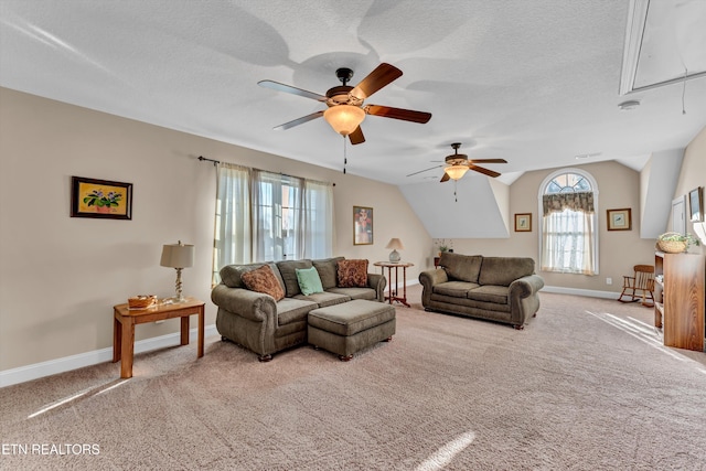 carpeted living room with ceiling fan, lofted ceiling, plenty of natural light, and a textured ceiling