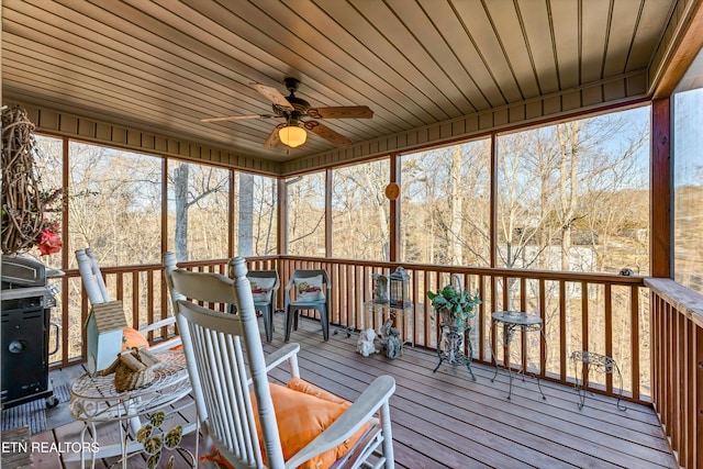 unfurnished sunroom with wood ceiling, ceiling fan, and a healthy amount of sunlight