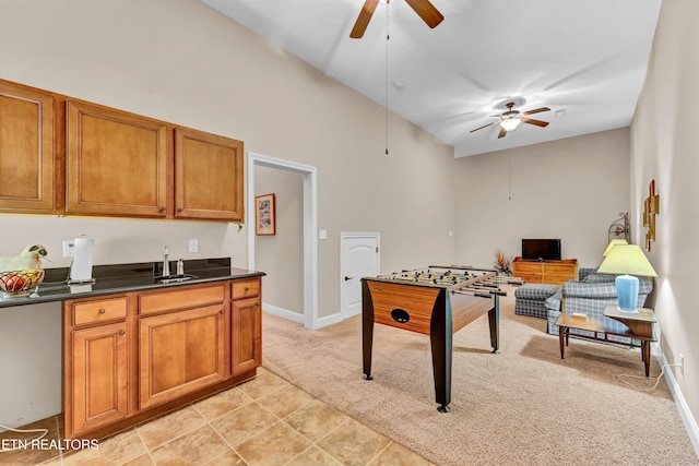 recreation room featuring vaulted ceiling, sink, light colored carpet, and ceiling fan