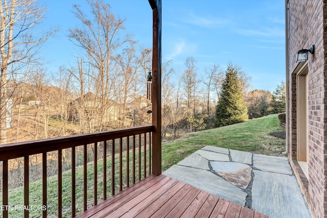 wooden deck featuring a lawn