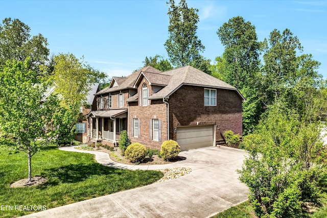 view of front facade with a porch, brick siding, driveway, a front lawn, and an attached garage