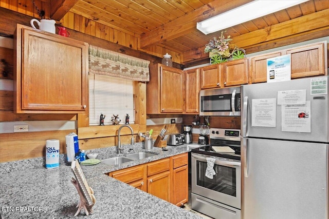 kitchen with appliances with stainless steel finishes, beamed ceiling, sink, light stone counters, and wooden ceiling