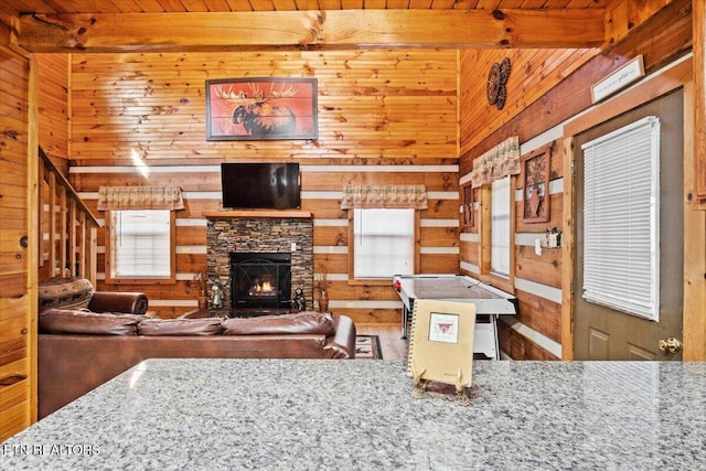 living room with a fireplace, wood ceiling, and wooden walls