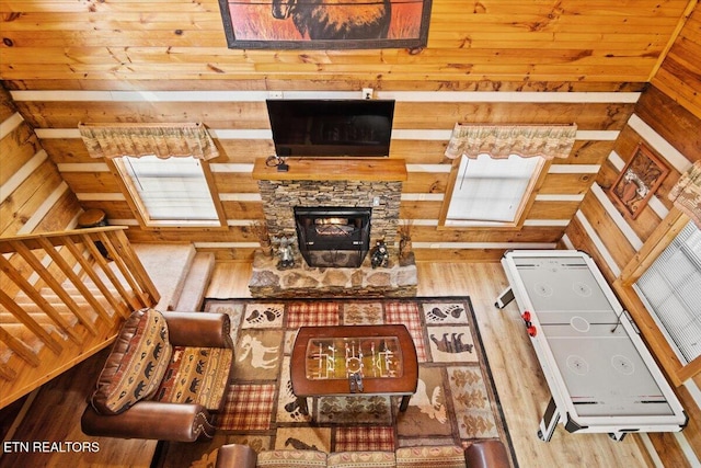 living room featuring lofted ceiling, hardwood / wood-style floors, wooden ceiling, and wood walls