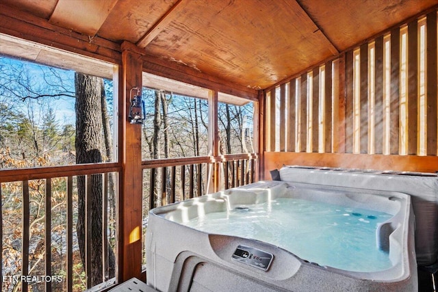 unfurnished sunroom with a hot tub and wood ceiling