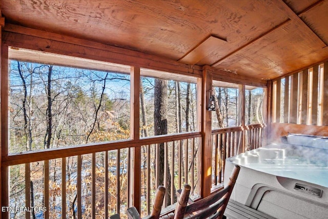 unfurnished sunroom featuring a jacuzzi, wooden ceiling, and a healthy amount of sunlight