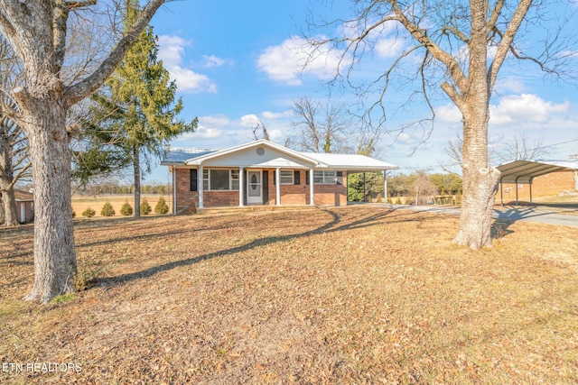 ranch-style house featuring a porch, a carport, and a front lawn