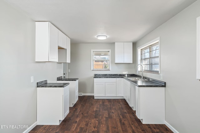 kitchen featuring white cabinetry, sink, and dark hardwood / wood-style floors