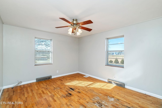 spare room featuring ceiling fan, plenty of natural light, and hardwood / wood-style floors