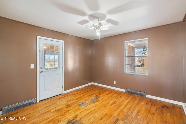 empty room with hardwood / wood-style flooring, ceiling fan, and plenty of natural light