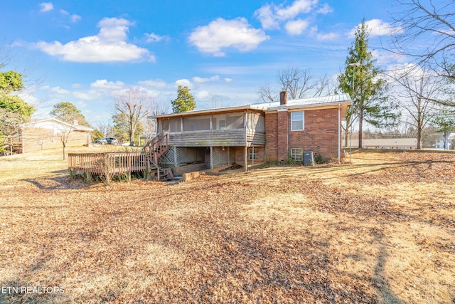 back of property with central AC unit, a sunroom, and a deck