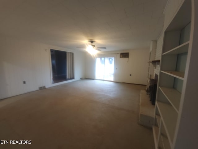 unfurnished living room with ceiling fan, a fireplace, and carpet