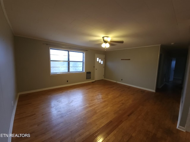 spare room with crown molding, dark hardwood / wood-style floors, and ceiling fan