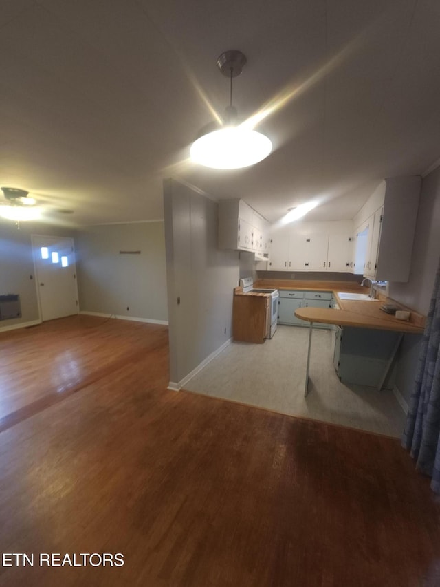 kitchen with sink, white cabinetry, light hardwood / wood-style flooring, kitchen peninsula, and white range with electric cooktop